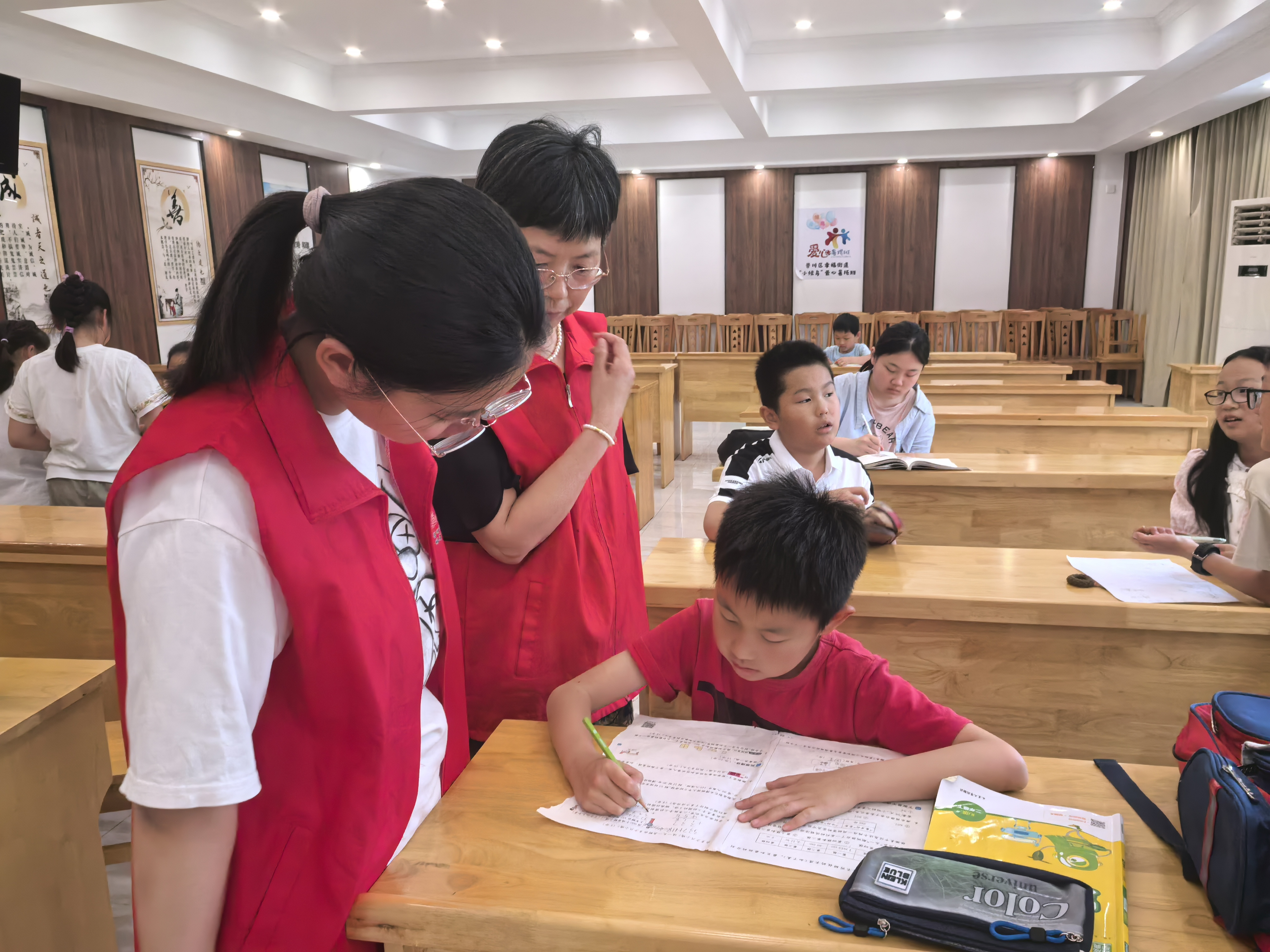 6月21日，崇川区幸福街道关工委开展“暖‘新’伙伴关爱计划幸福街道‘小候鸟’周末爱心托班”，“五老”志愿者为孩子们辅导作业。(幸福街道关工委).jpg