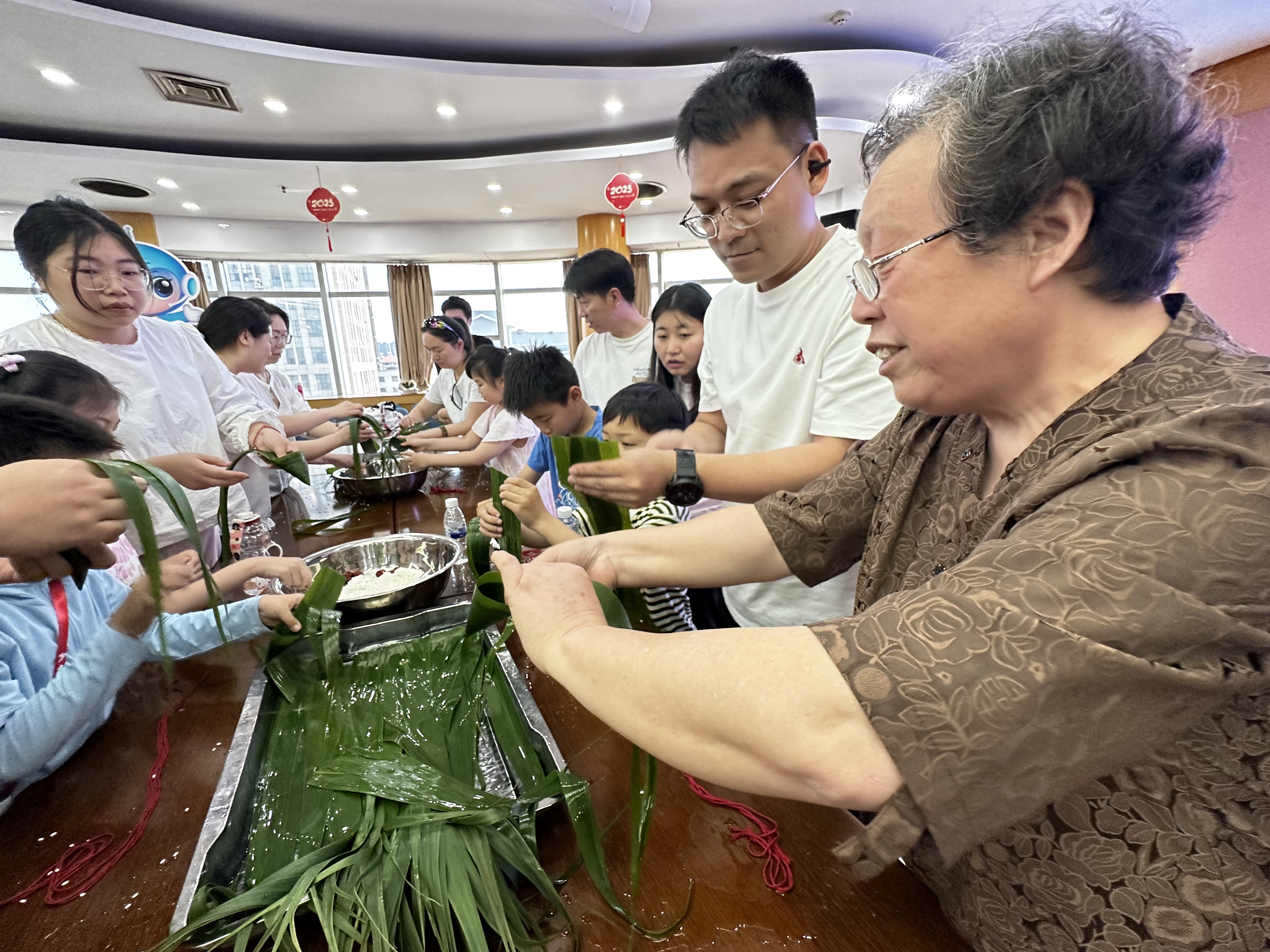 6月7日，崇川区虹桥街道青年社区关工委在科技馆组织开展“浓情迎端午，亲子‘粽’动员活动，在“粽艺名师团”奶奶们的现场指导下，孩子和家长们好好体验了一把包粽子的乐趣。（青年社区关工委）.jpg