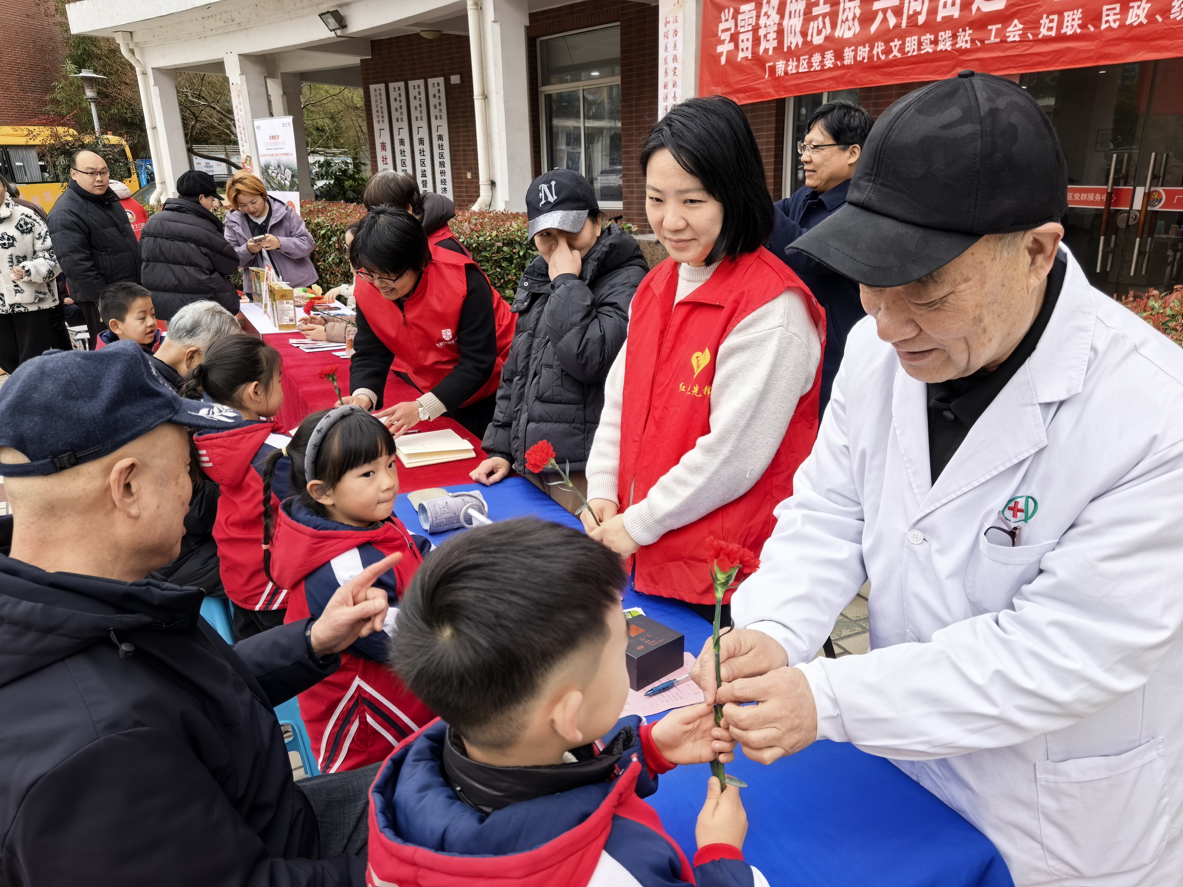 3月5日上午，崇川区文峰街道厂南社区关工委在活动广场举办了“学雷锋做志愿·共同奋进十五五”主题志愿服务活动。活动现场，社区工作人员组织孩子们为参与活动的志愿者们献上鲜花，以此表达最真挚的敬意。（张云华）.jpg
