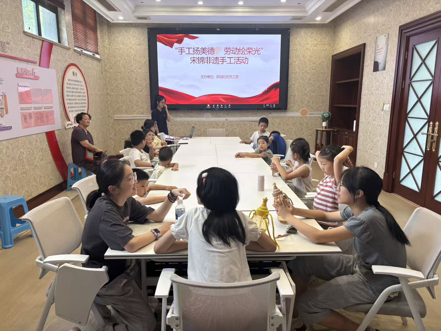 7月28日，崇川区文峰街道新城社区关工委组织辖区青少年开展“手工扬美德 劳动绘荣光”宋锦非遗手工活动，带领孩子们亲手制作宋锦冰箱贴，让大家在指尖体验中感受非遗文化的独特魅力。（新城社区关工委）.jpg